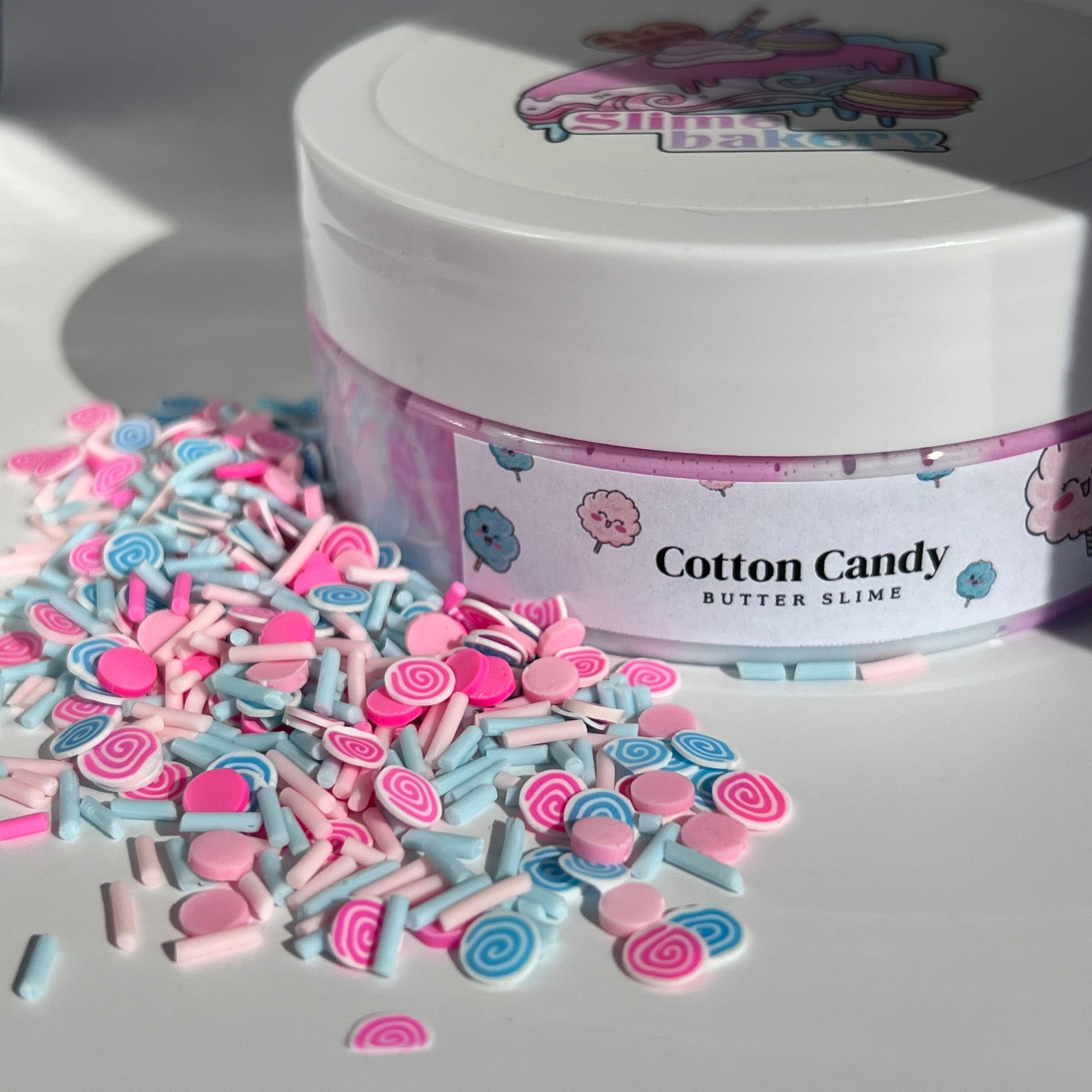Butter Slime Cotton Candy - Pastel pink and blue swirl slime featuring cotton candy charms, providing a glossy, spreadable consistency and soothing cotton candy aroma.