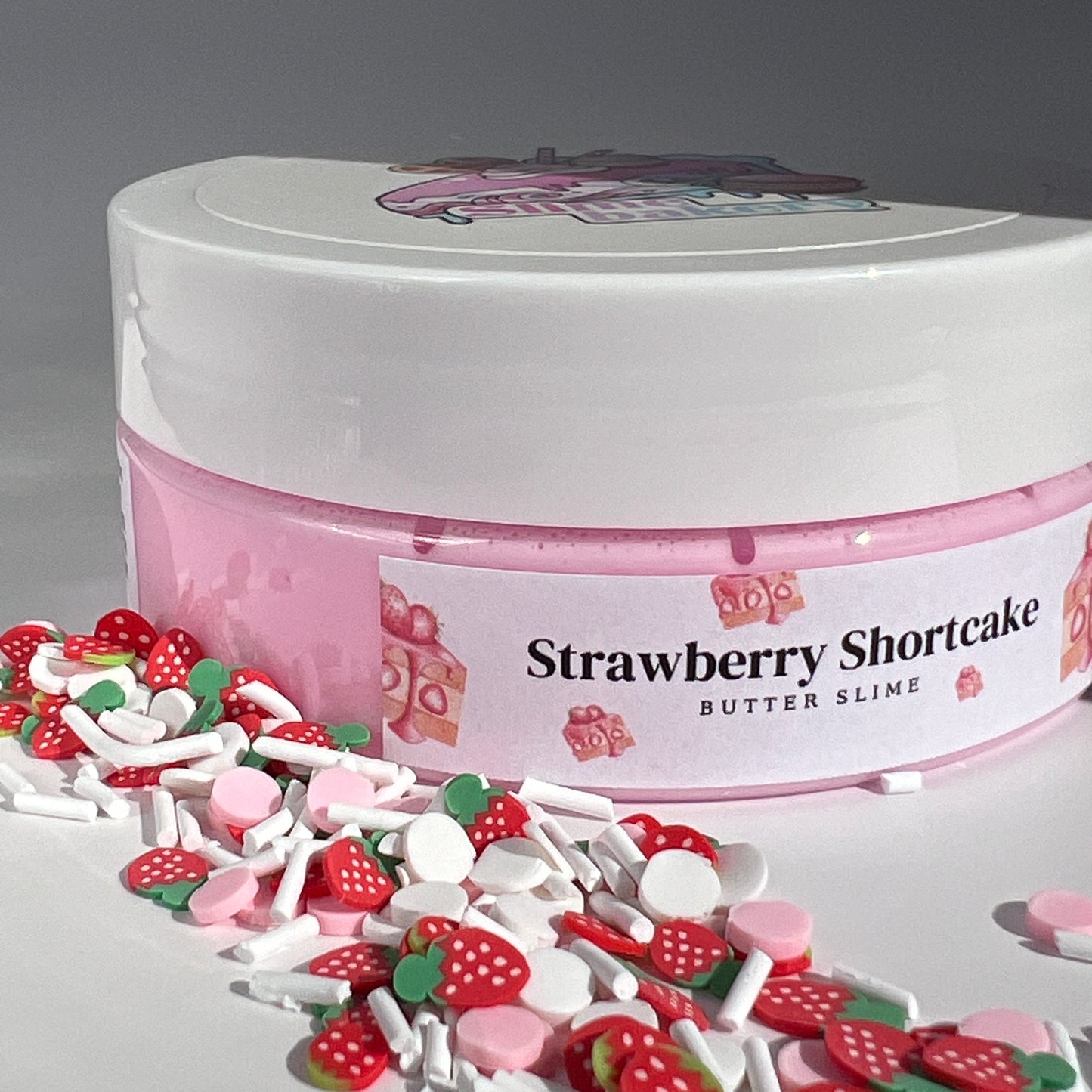 Creamy pink butter slime with a soft, buttery texture, accented by strawberry shortcake-themed charms. Infused with a rich strawberry shortcake scent, perfect for stress relief and tactile enjoyment.