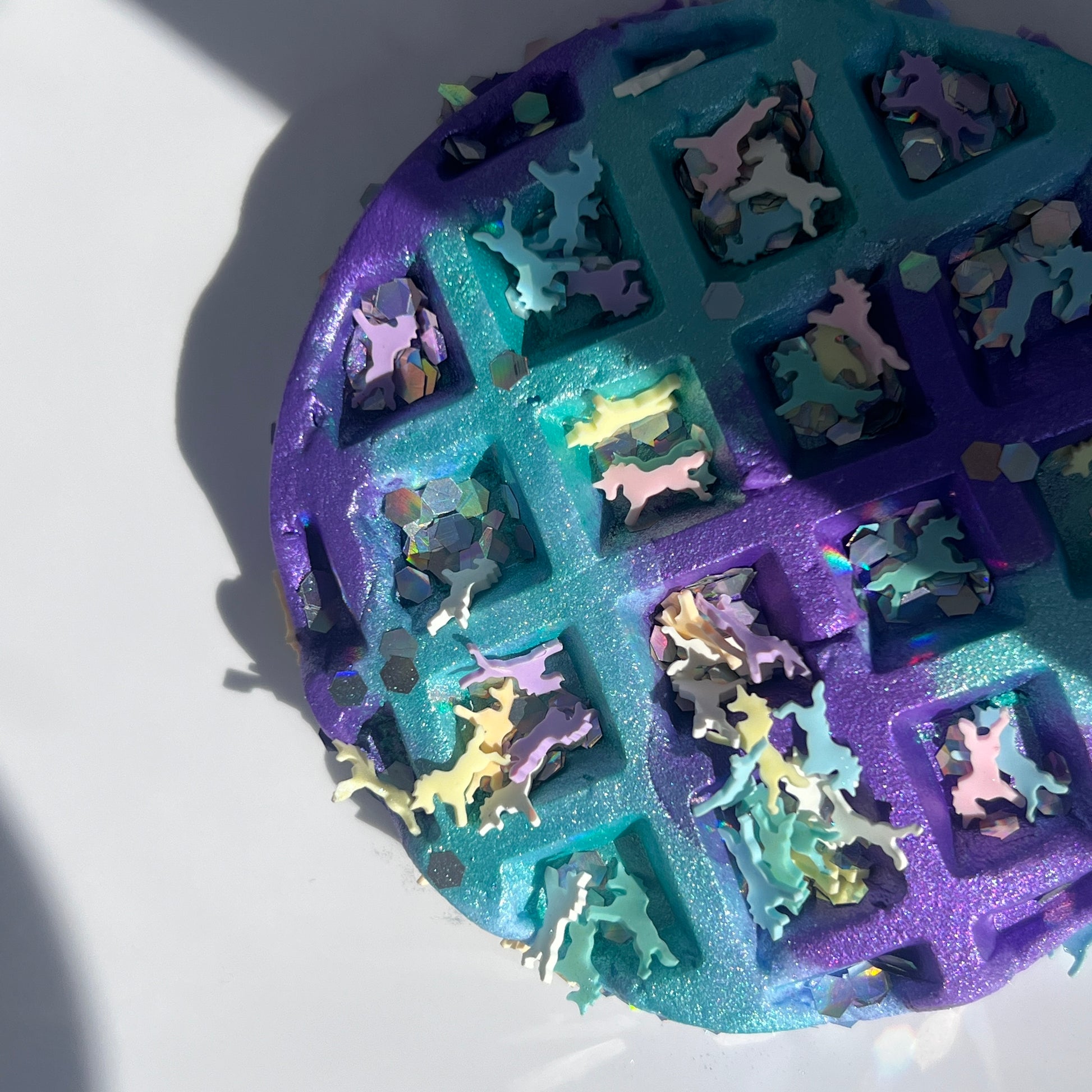 Vibrant turquoise butter slime with a purple and blue clay waffle, accompanied by whimsical polymer unicorn charms. Soft and stretchy texture, scented like sweet cotton candy, perfect for sensory play and relaxation