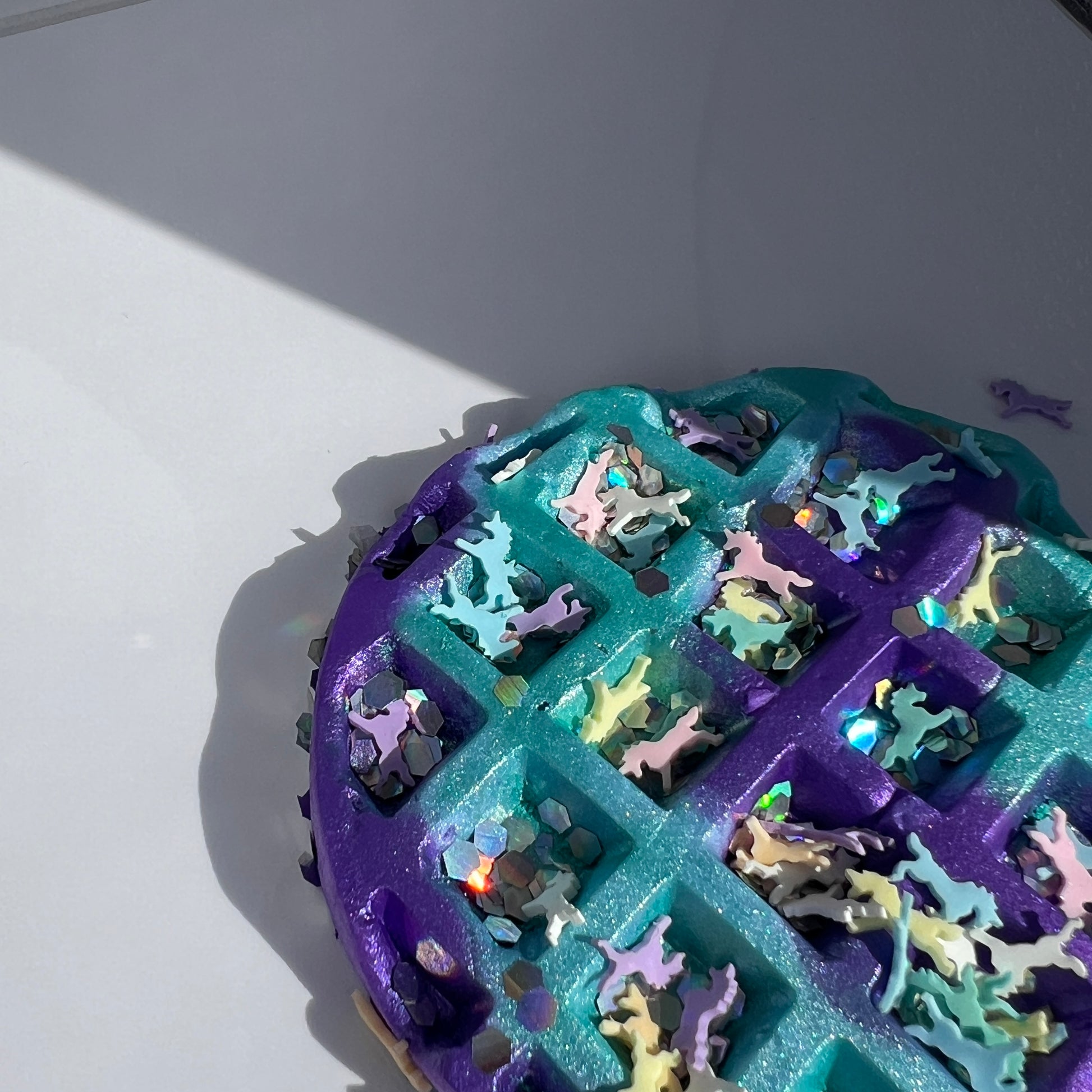 Vibrant turquoise butter slime with a purple and blue clay waffle, accompanied by whimsical polymer unicorn charms. Soft and stretchy texture, scented like sweet cotton candy, perfect for sensory play and relaxation
